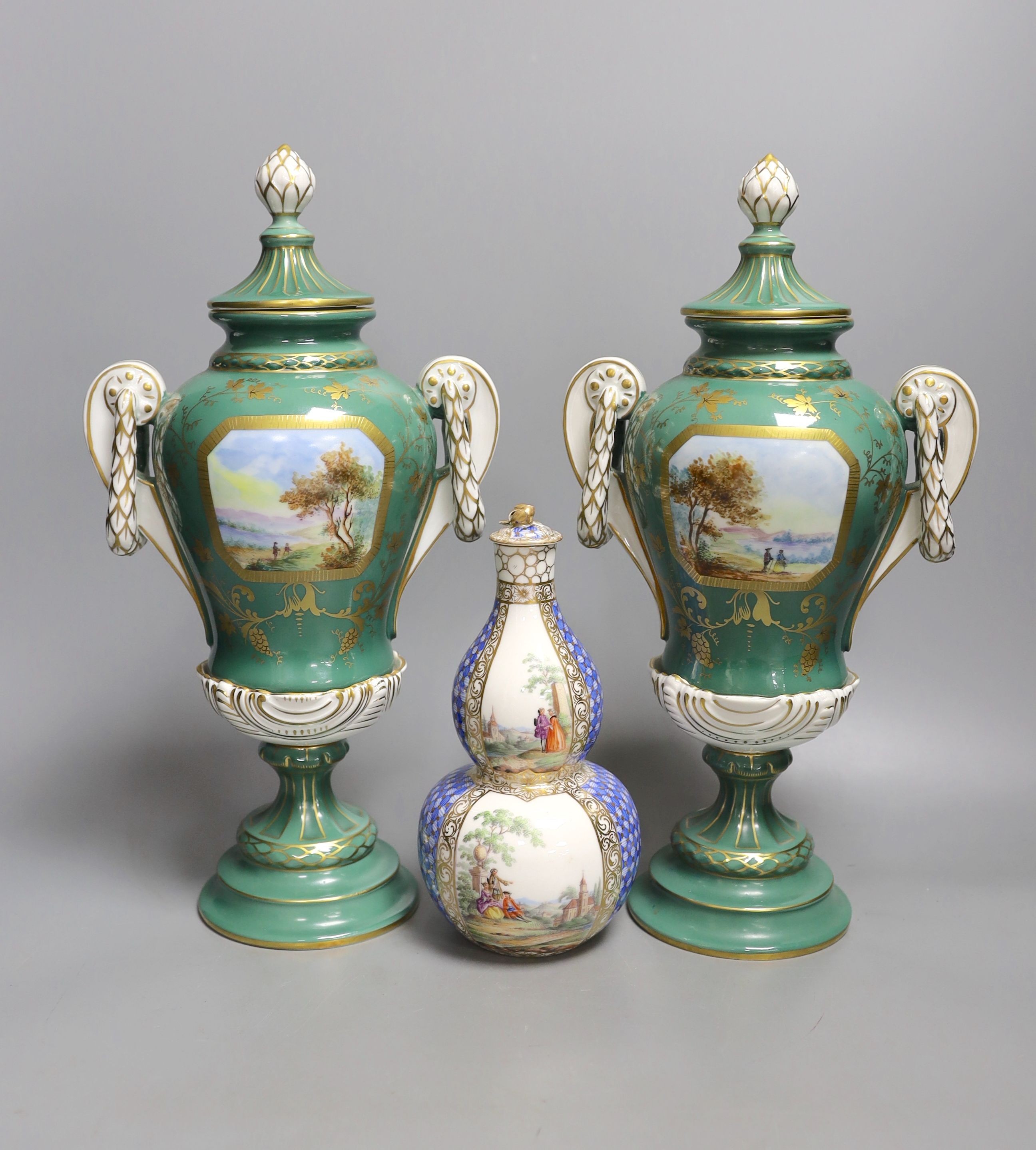 A pair of early 20th century Dresden vases painted with landscapes on an avocado green ground, 24cm high together with a German bottle vase and cover painted with four landscape panels separated by blue and white panels
